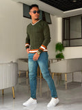 Slim-fit mid-wash blue jeans paired with an olive green sweater.